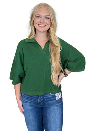 Solid 3/4 sleeve knit top featuring open V-neck collar