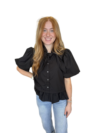 Solid short sleeve top featuring bow and ruffle detail