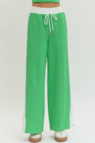 Solid wide leg knit pants featuring elastic waistband with drawstring.