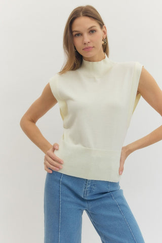 Solid mock neck sleeveless knit top featuring ribbed hem