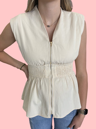 sleeveless peplum top featuring wide smocked waist and zipper