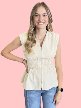 sleeveless peplum top featuring wide smocked waist and zipper