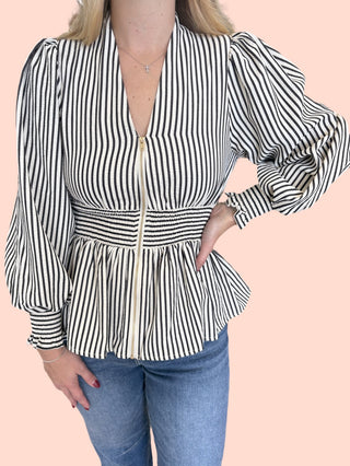 Stripe print long sleeve peplum top featuring smocked waistband and V-neck