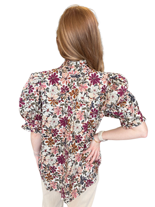 Floral print short puff sleeve top featuring ruffled neckline detail. Button closure at front