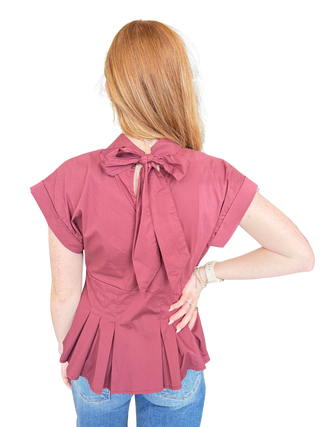 Solid ¾ puff sleeve top featuring V-neck and bow tie detail