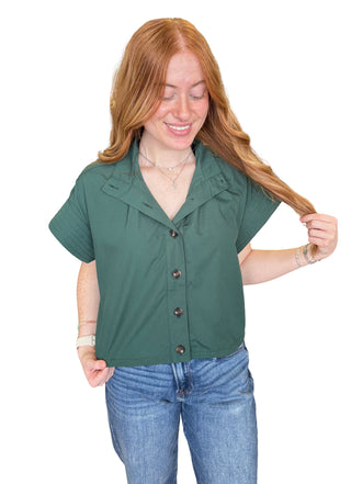 Solid short sleeve top featuring stand neck and button closure at front